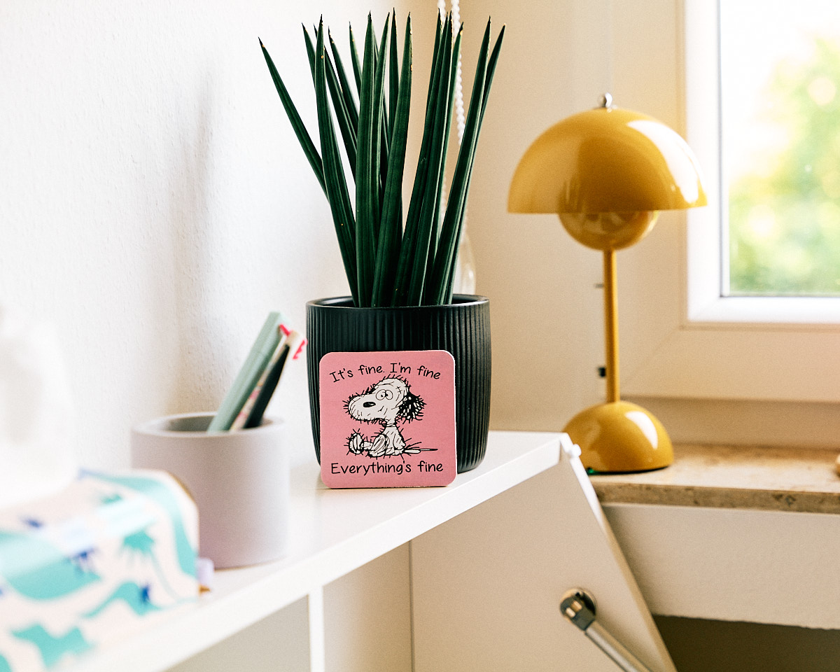 Pflanze und gelbe Flowerpot-Lampe auf dem Sekretär, Snoopy-Untersetzer